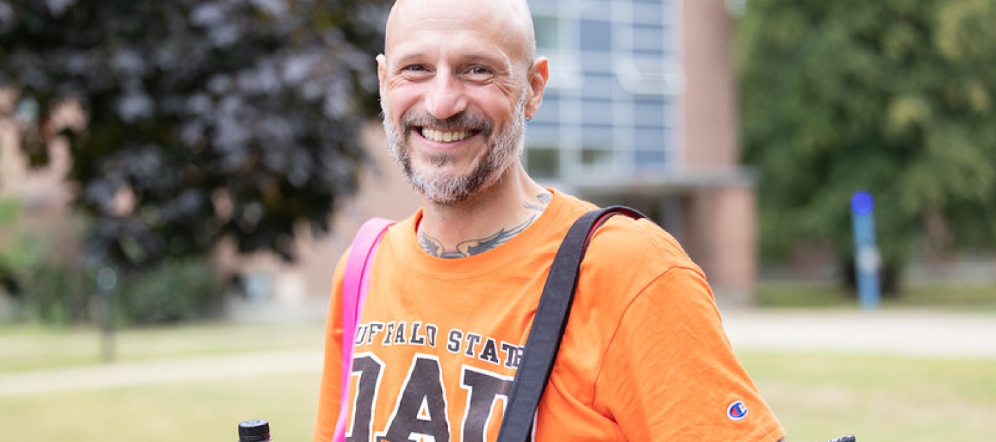 Man wearing an orange Buffalo State Dad T-shirt