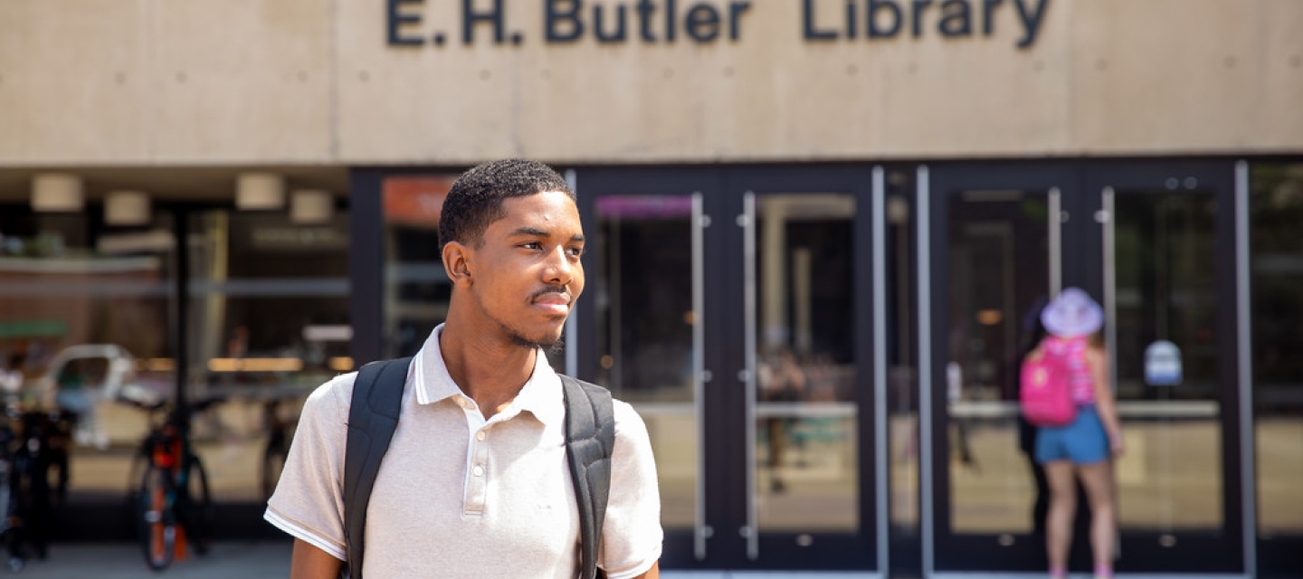 Student walking outside Butler Library 